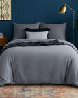 Dark sateen duvet cover set on bed with grey pillows in modern bedroom setting