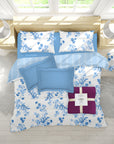 Floral bedding set with blue and white patterns on a bed in a bright room.