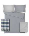 Gray textured bedding set with plaid throw blanket on a white background