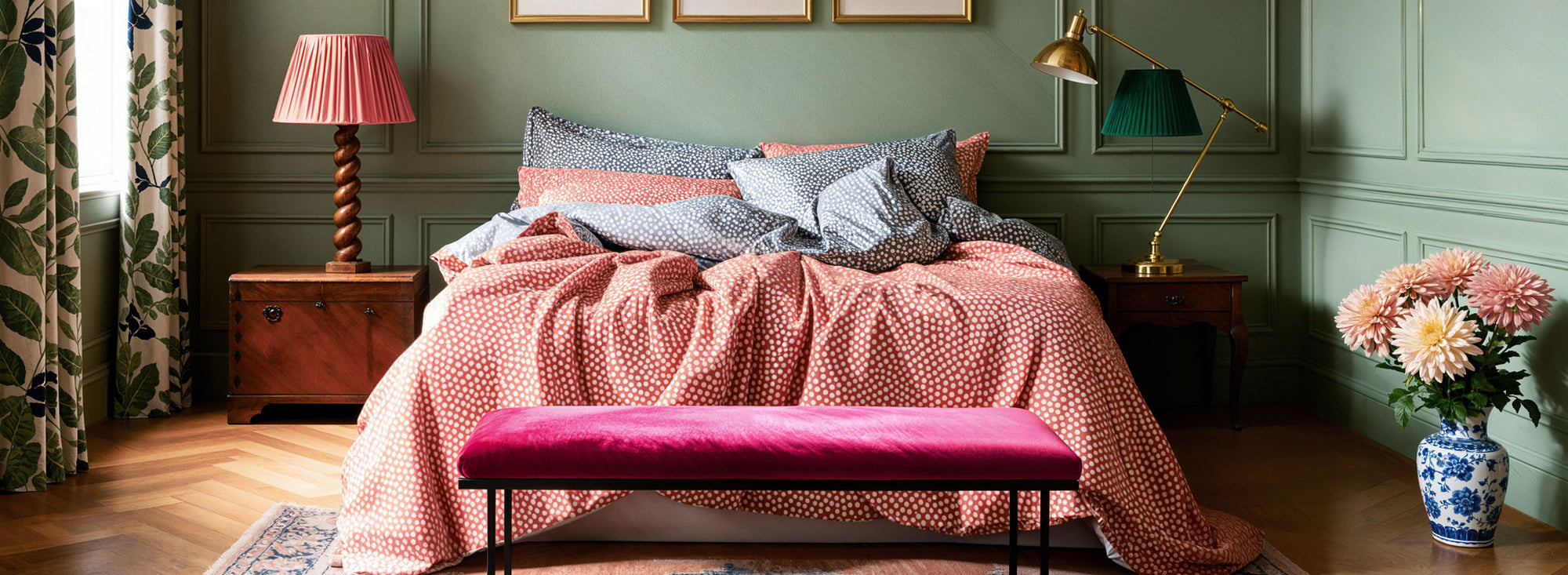 Neatly made bed with coral red orange bedding in a bedroom setting to chase away the monsters of Halloween