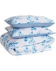 Blue floral duvet cover set with matching pillows on white background