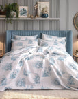 Blue and white Toile de Jouy duvet cover set on bed in modern bedroom with gold lamps.