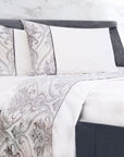 White and gray floral patterned bedding set on a modern bed with matching pillows