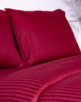 Une paire de taies d'oreiller Oxford en satin de coton 100 % à rayures bordeaux