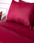 Une paire de taies d'oreiller Oxford en satin de coton 100 % à rayures bordeaux