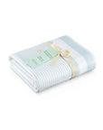 Folded white and teal striped peshtemal towel with cream ribbon and tag on white background