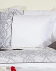 White pillowcases with elegant gray damask pattern on a neatly made bed