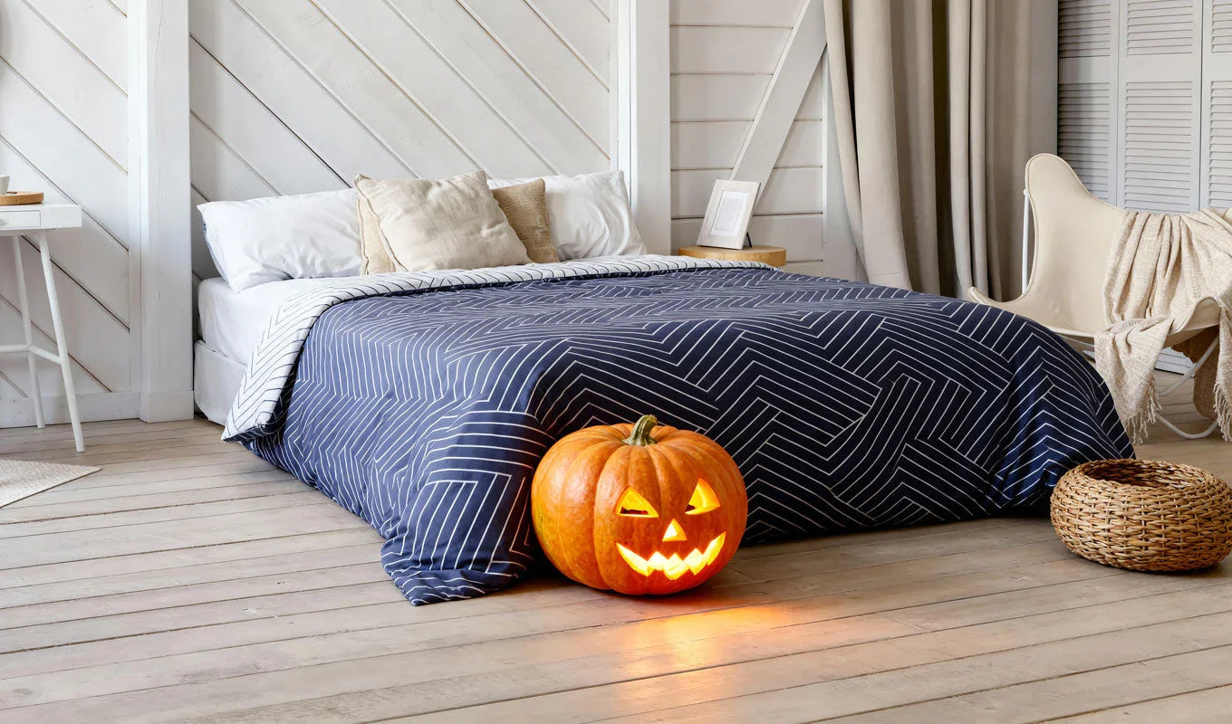 Bedroom with a pumpkin on the floor near a bed with a blue geometric patterned comforter.