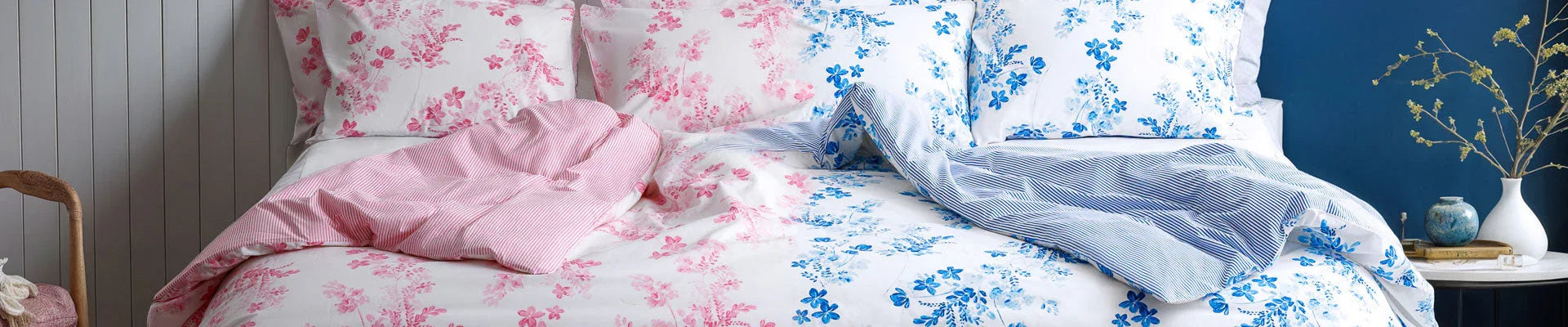 Floral bedding with pink and blue patterns on a neatly arranged bed in a stylish bedroom
