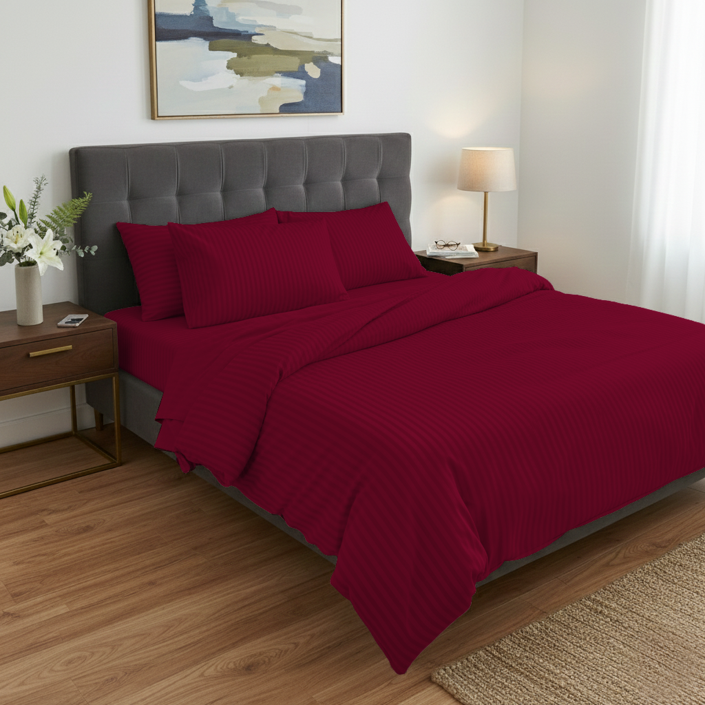 Bedroom with red bedding on a bed, nightstands, and a lamp.