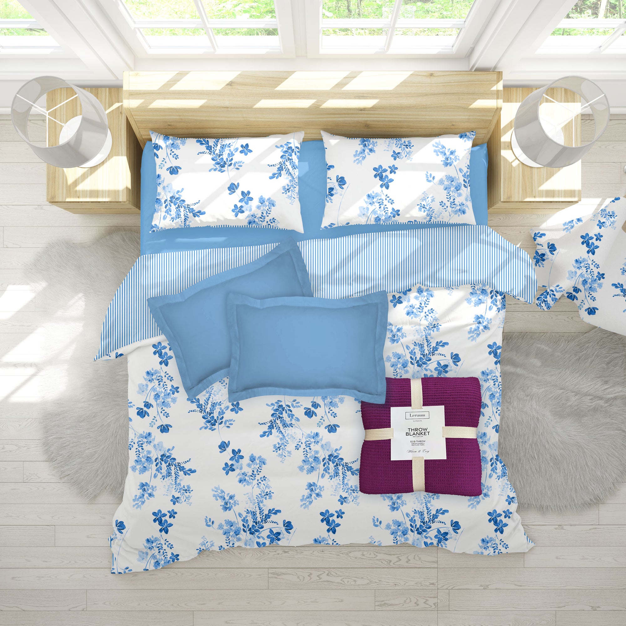 Floral bedding set with blue and white patterns on a bed in a bright room.