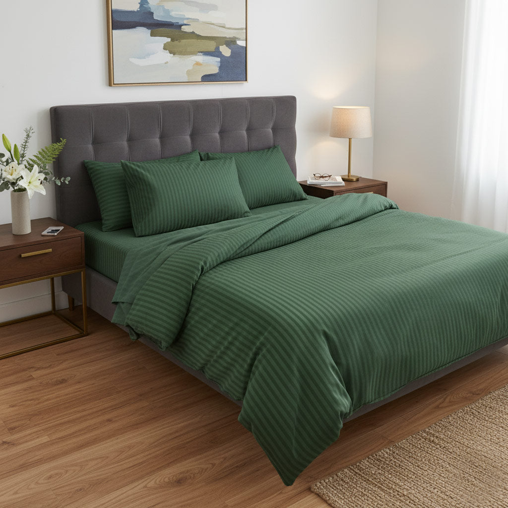 Bedroom with green bedding and a gray upholstered headboard.