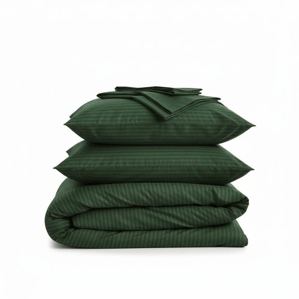 Stack of green cotton sateen bedding bundle including a duvet cover, two pillowcases, and a flat sheet on a white background