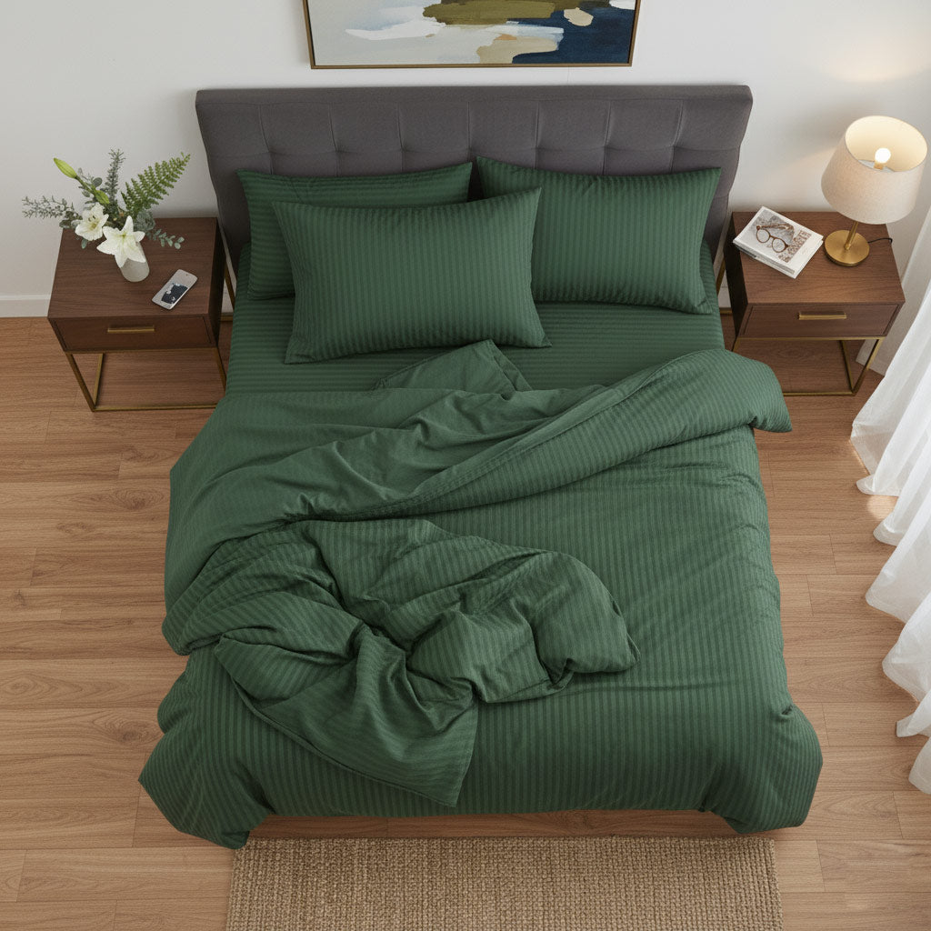 Green cotton sateen bedding set on a bed in a bedroom with wooden floors and side tables.