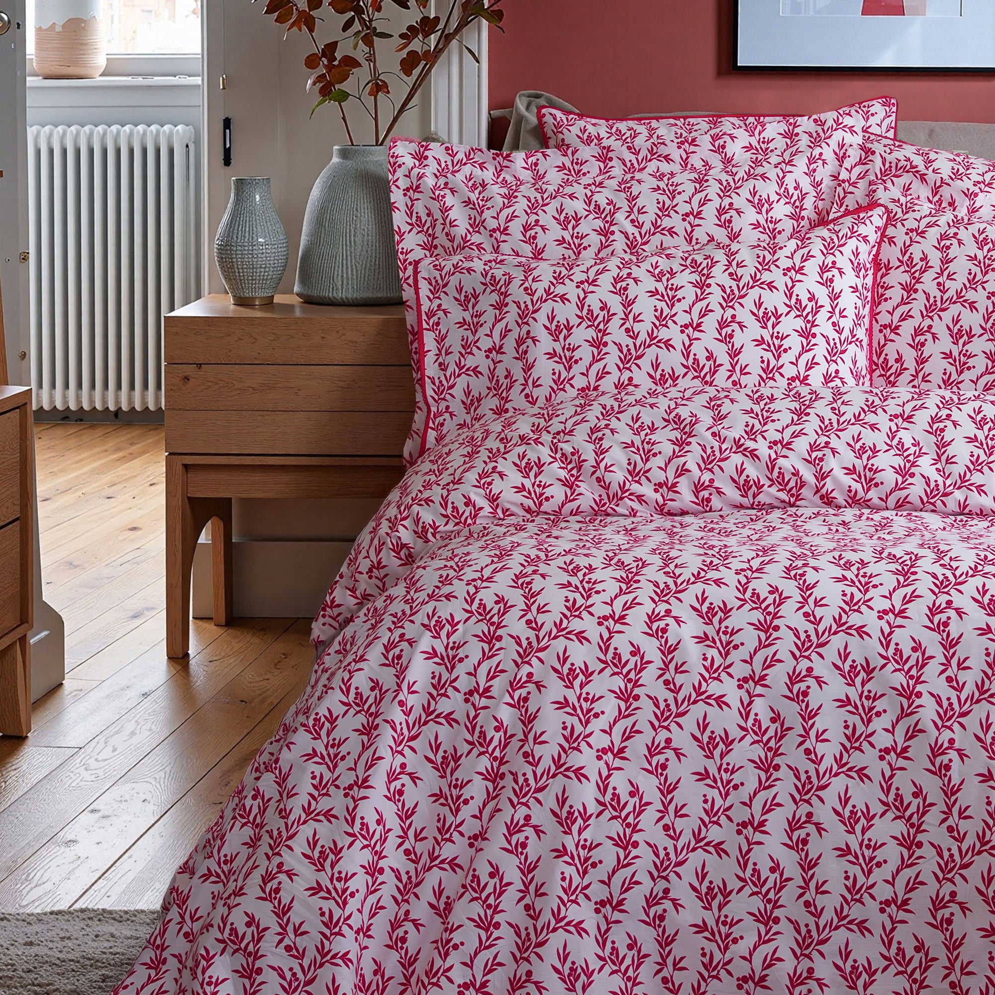 Bed with red and white patterned bedding in a bedroom setting.