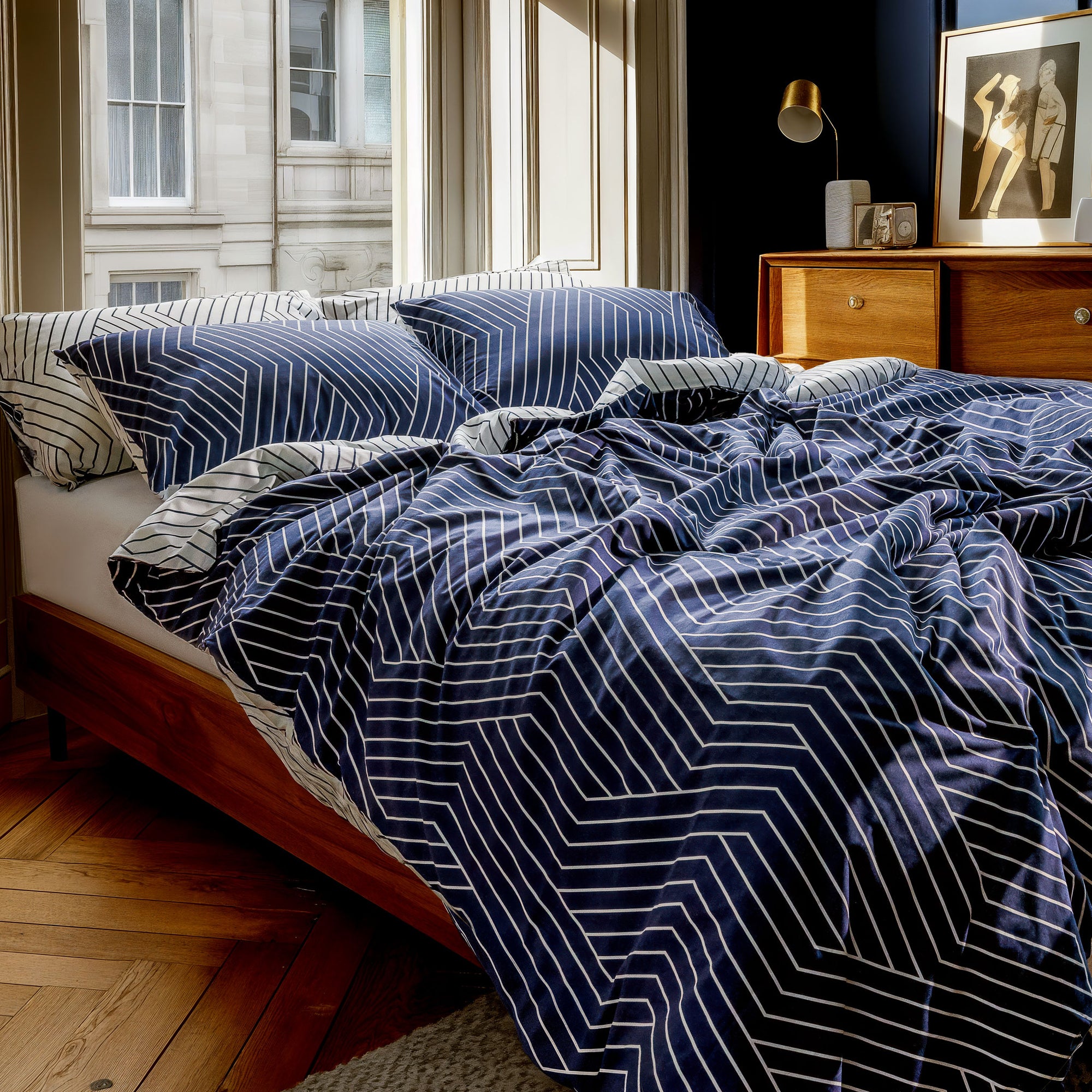 Bed with blue and white striped bedding in a bedroom setting.