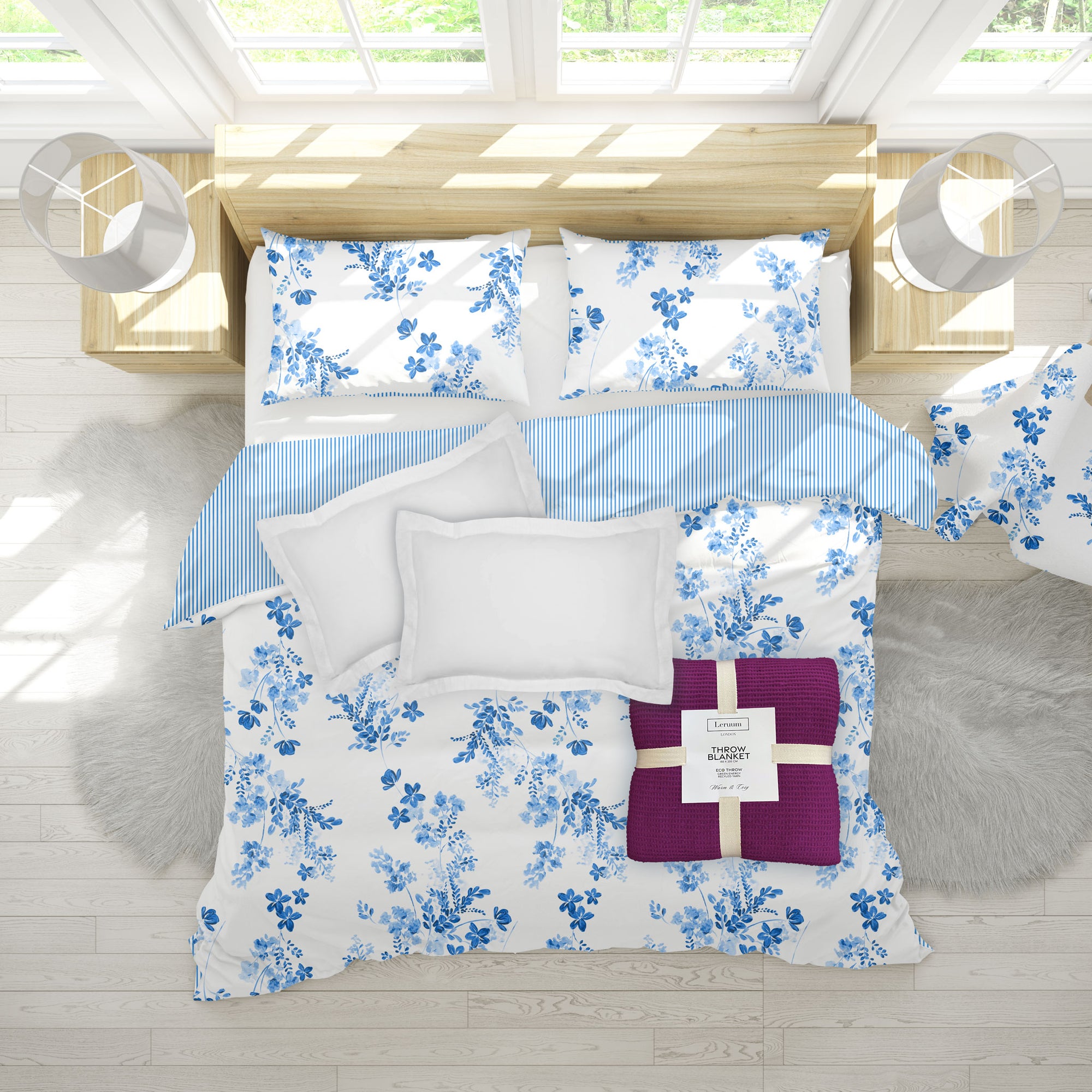 Floral bedding set with blue and white patterns on a bed in a bright room.