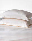 Une paire de taies d'oreiller Oxford en satin de coton 100 % à rayures blanc perle